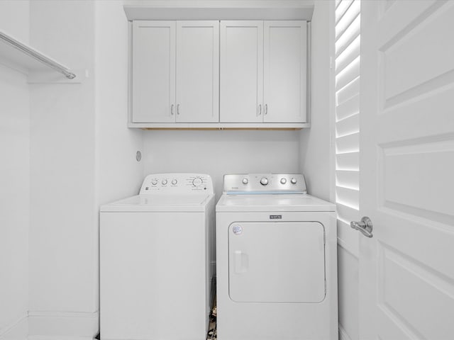 laundry area featuring washing machine and dryer and cabinets