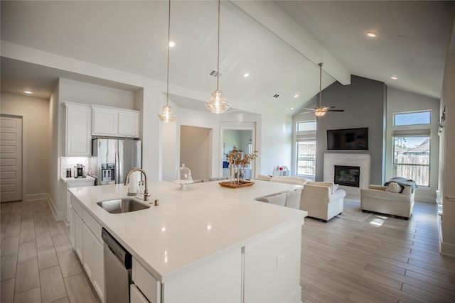 kitchen featuring hanging light fixtures, an island with sink, appliances with stainless steel finishes, plenty of natural light, and white cabinetry