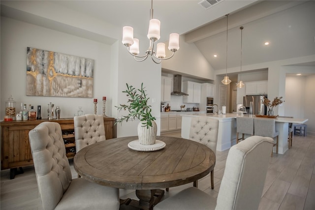 dining space with a chandelier, light wood-type flooring, and vaulted ceiling with beams