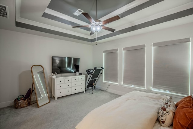 carpeted bedroom featuring a tray ceiling and ceiling fan