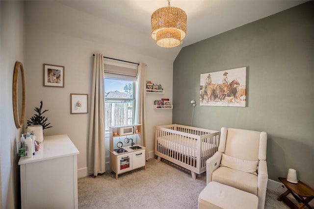 carpeted bedroom featuring vaulted ceiling and a nursery area