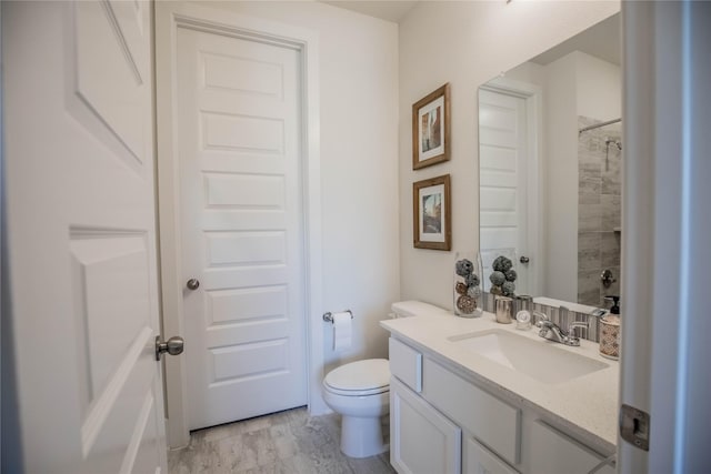 bathroom with a shower, vanity, and toilet