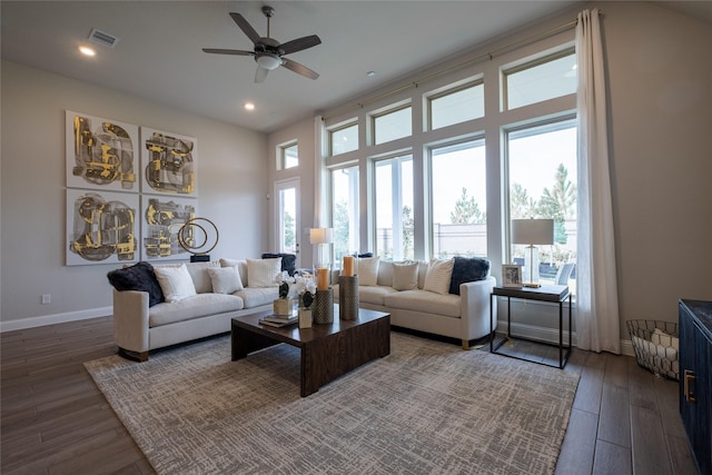 living room with dark hardwood / wood-style flooring, a wealth of natural light, and ceiling fan