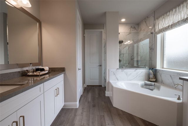 bathroom with separate shower and tub, vanity, and wood-type flooring