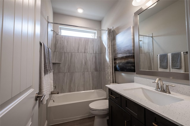 bathroom featuring toilet, shower / tub combo with curtain, and vanity