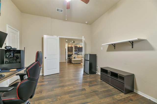 office with ceiling fan, dark wood-type flooring, and a high ceiling