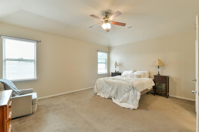 bedroom featuring ceiling fan, light colored carpet, and multiple windows