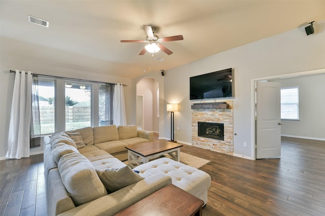 living room with a fireplace, ceiling fan, a healthy amount of sunlight, and dark wood-type flooring