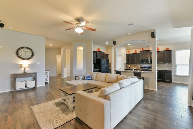 living room with dark hardwood / wood-style flooring and ceiling fan