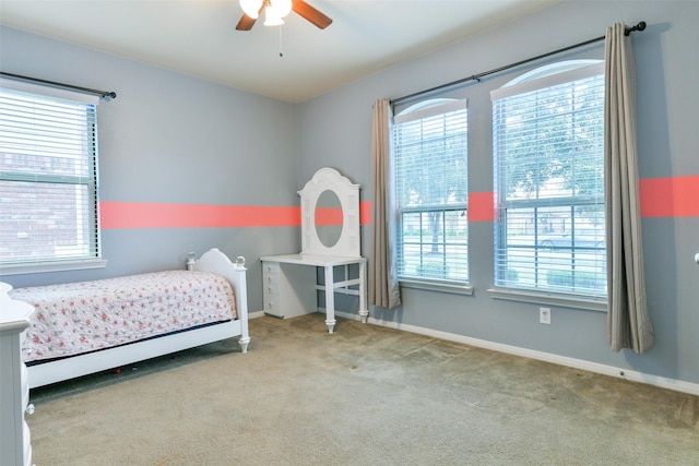 carpeted bedroom featuring multiple windows and ceiling fan