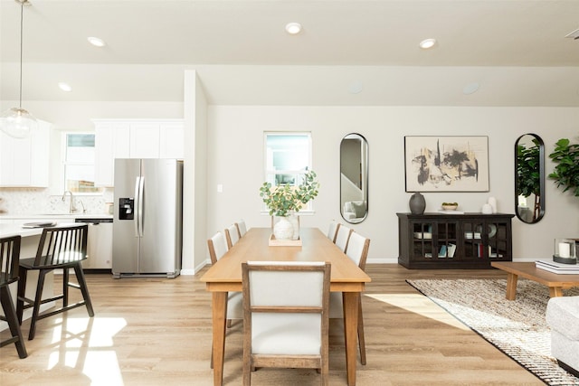 dining area with a healthy amount of sunlight, light wood-type flooring, and sink