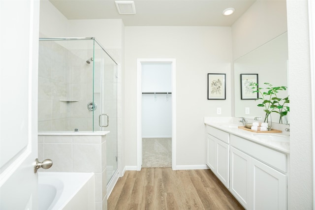 bathroom with separate shower and tub, hardwood / wood-style floors, and vanity