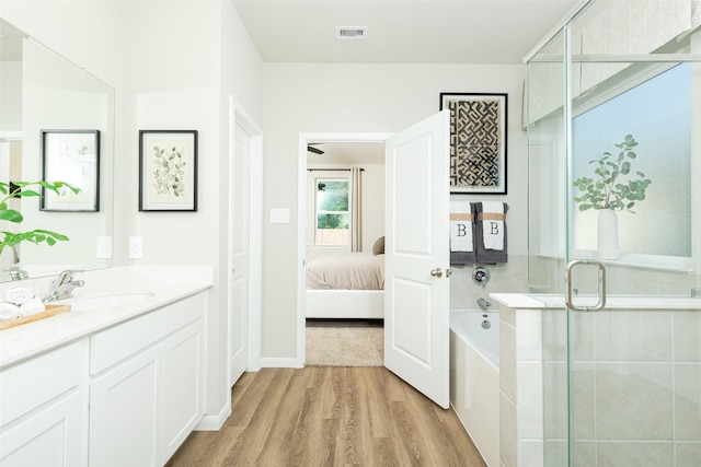 bathroom featuring separate shower and tub, vanity, and wood-type flooring