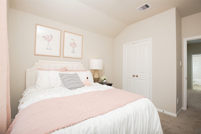 carpeted bedroom with a closet and lofted ceiling