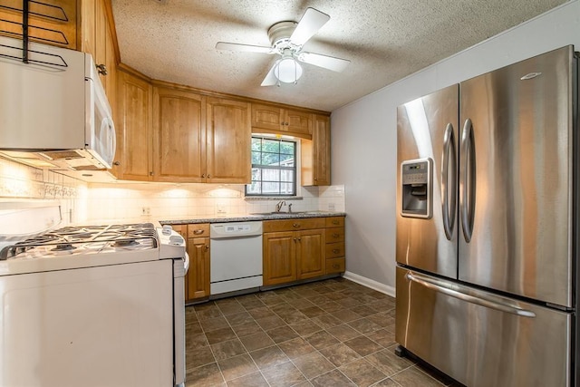 kitchen featuring ceiling fan, sink, a textured ceiling, white appliances, and decorative backsplash