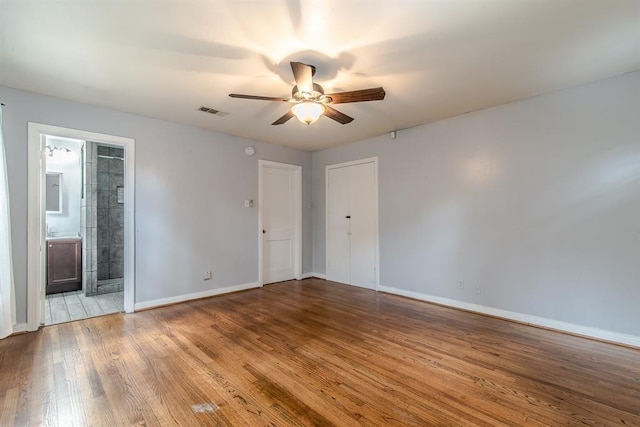 empty room with ceiling fan and light hardwood / wood-style flooring