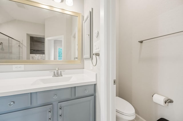 bathroom featuring vanity, toilet, and an enclosed shower