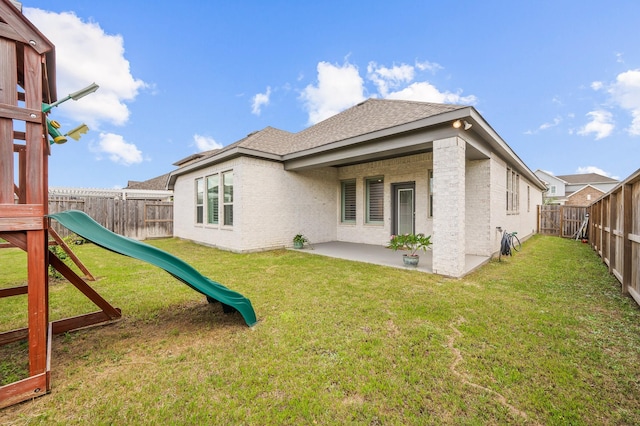 rear view of house featuring a patio area, a playground, and a yard