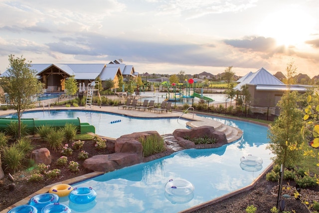 pool at dusk with a patio area