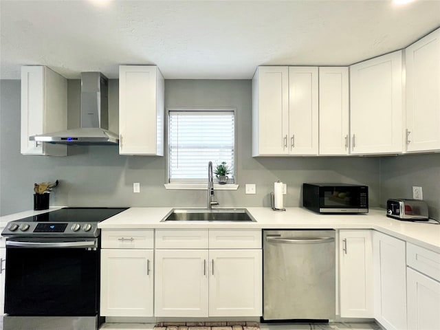 kitchen with white cabinets, sink, wall chimney exhaust hood, and stainless steel appliances