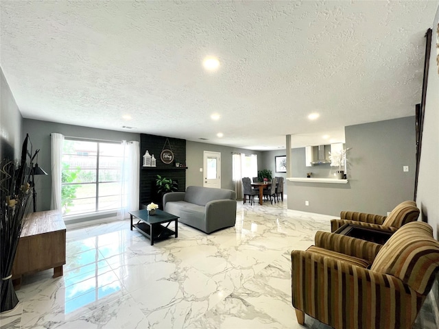 living room featuring a textured ceiling and a brick fireplace