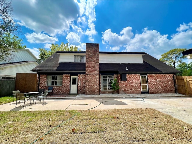 rear view of house featuring a yard and a patio