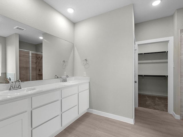 bathroom with vanity and a shower with shower door