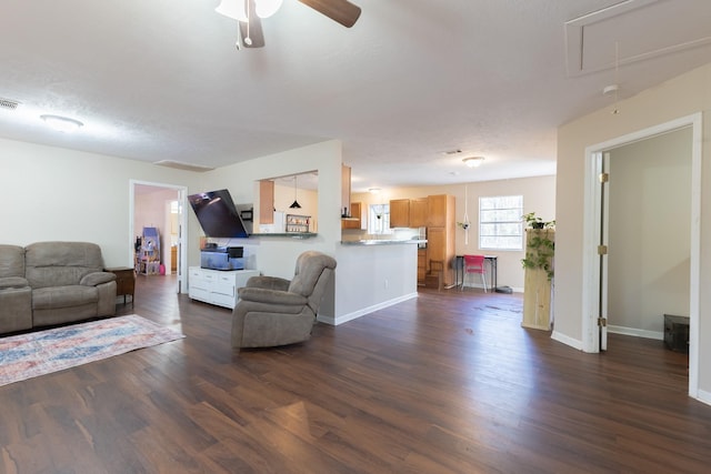 living room featuring a textured ceiling, dark wood-type flooring, and ceiling fan