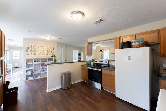 kitchen with a wealth of natural light, stainless steel range with electric cooktop, white refrigerator, kitchen peninsula, and dark wood-type flooring