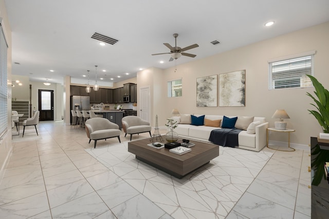 living room featuring ceiling fan, a healthy amount of sunlight, and sink