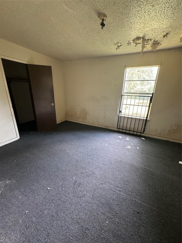 unfurnished room with a textured ceiling