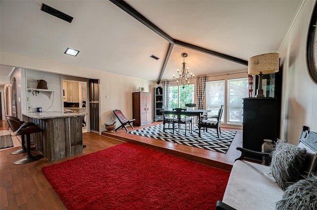 living room with vaulted ceiling with beams, dark hardwood / wood-style flooring, and an inviting chandelier