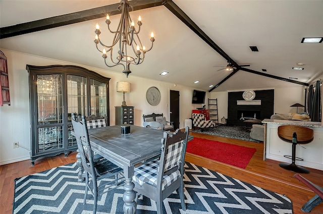 dining space featuring hardwood / wood-style floors, lofted ceiling with beams, and ceiling fan with notable chandelier