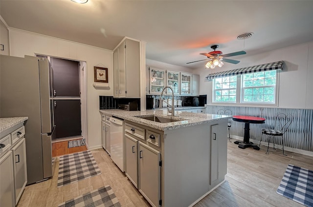 kitchen featuring ceiling fan, sink, light hardwood / wood-style flooring, kitchen peninsula, and white dishwasher