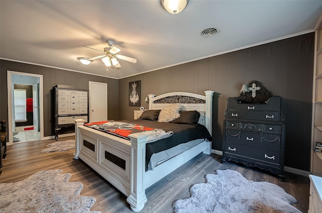 bedroom featuring dark hardwood / wood-style flooring, ceiling fan, and ornamental molding