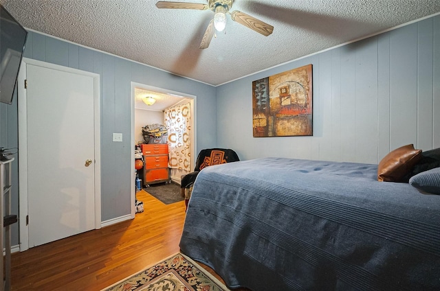 bedroom featuring hardwood / wood-style floors, a textured ceiling, and ceiling fan