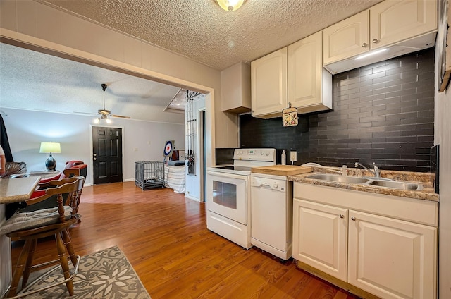 kitchen featuring light wood-type flooring, a textured ceiling, white appliances, ceiling fan, and sink