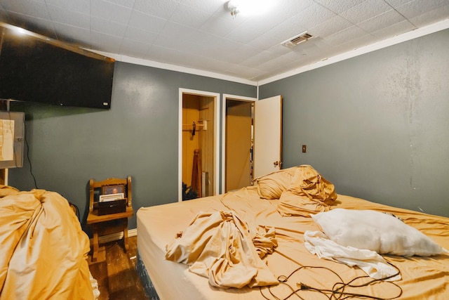 bedroom with dark hardwood / wood-style floors and ornamental molding