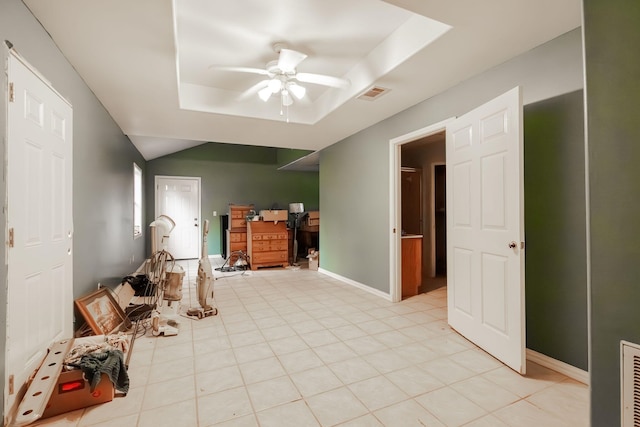 interior space featuring a raised ceiling and ceiling fan