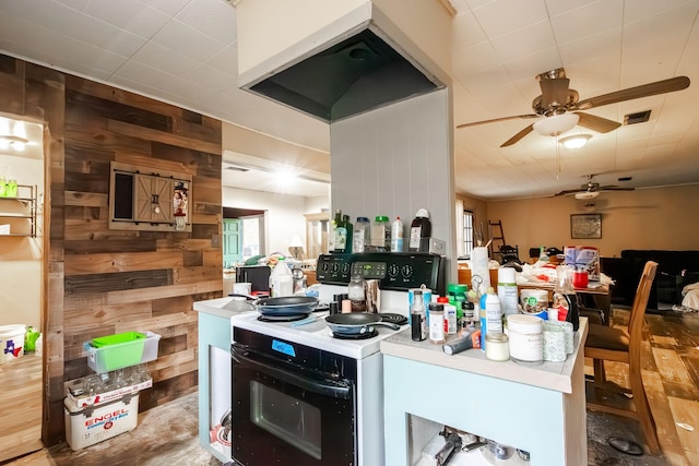 kitchen with electric range, ceiling fan, and wooden walls