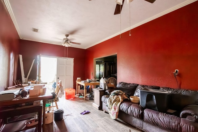 interior space with ceiling fan, wood-type flooring, and ornamental molding