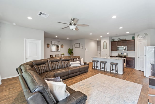 living area with dark wood finished floors, recessed lighting, visible vents, and baseboards