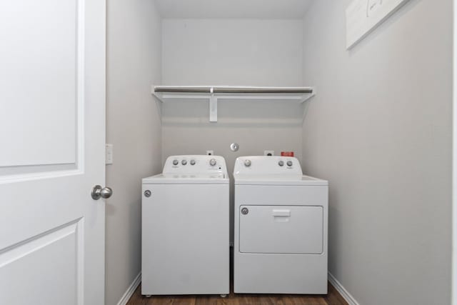 laundry room featuring laundry area, baseboards, dark wood-style flooring, and washing machine and clothes dryer