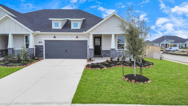 craftsman-style home featuring a garage, covered porch, and a front lawn