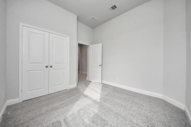 unfurnished bedroom featuring carpet floors, a closet, visible vents, and baseboards