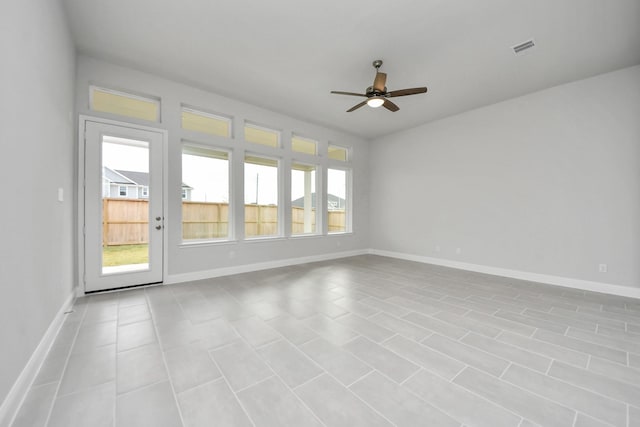 spare room featuring baseboards, visible vents, and a ceiling fan