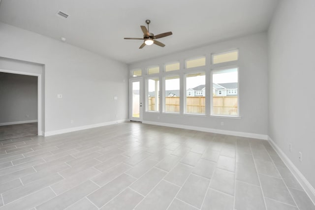 spare room with a ceiling fan, visible vents, and baseboards