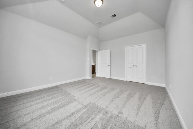 unfurnished bedroom featuring lofted ceiling, baseboards, visible vents, and carpet flooring