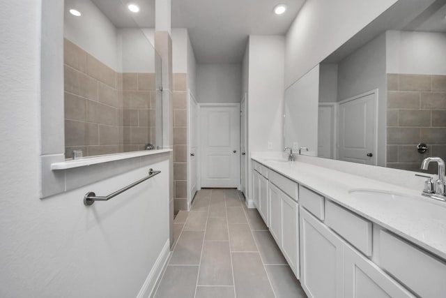 full bath with double vanity, tile patterned flooring, a sink, and recessed lighting