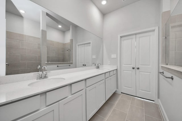 full bathroom with double vanity, walk in shower, a sink, and tile patterned floors